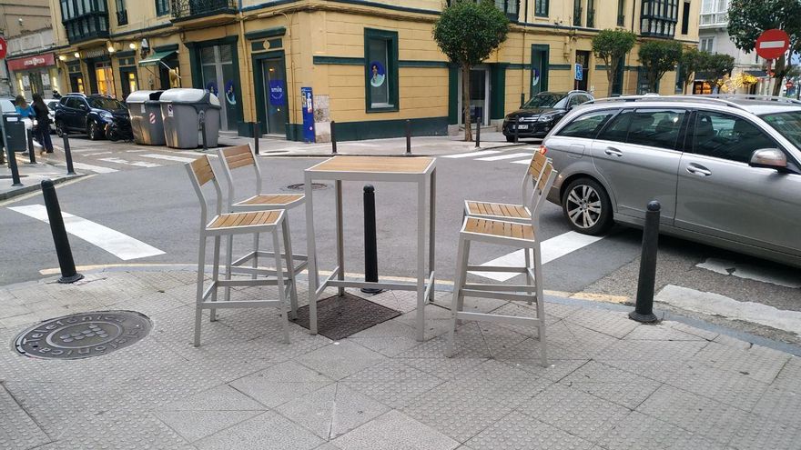 Mesa y sillas de bar en una calle de Santander.