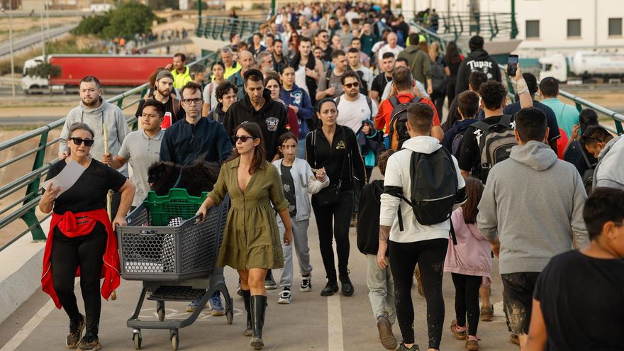 Un grupo de voluntarios llena la pasarela que une València con las localidades del sur.