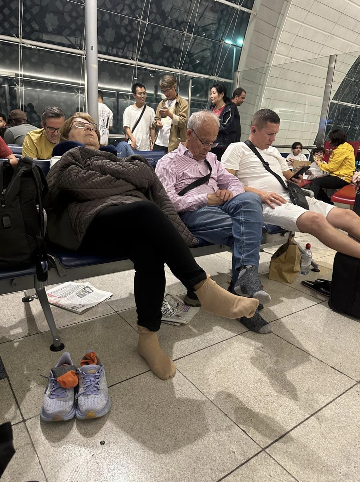 Uno de los matrimonios canarios bloqueados en Dubai tratan de descansar en la terminal.