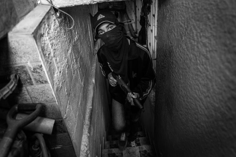 Freddy, de 16 años, miembro de una banda de secuestradores, fotografiado en una casa segura en una barriada de Caracas
