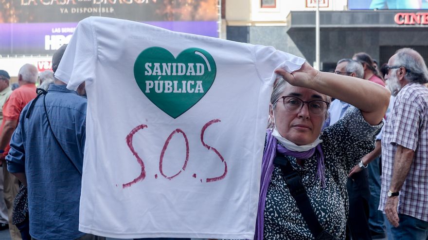 Una mujer muestra una camiseta que reza 'Sanida Pública SOS'.