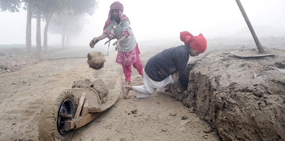 Rabia y su hermano Sidra son pakistaníes. Tienen 8 y 10 años. A pesar de que ambos estudian, deben ayudar en la economía familiar y por eso trabajan en la fabricación de materiales de construcción. Sin zapatos, sin acceso a un baño, sin agua potable y sin tener un descanso. Sólo comen una vez al día. (Umar Farooq/ActionAid)