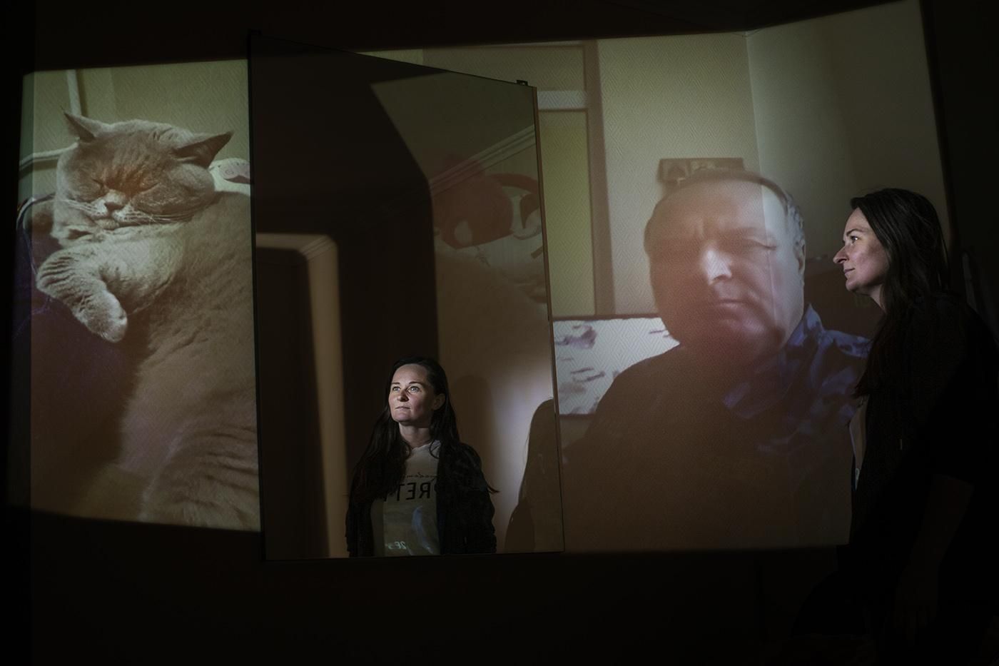 Lyudmila con varias fotos de fondo donde aparecen su gato y su padre.