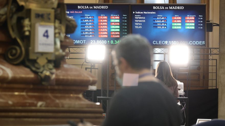 Archivo - Un hombre delante de dos paneles con valores del Ibex 35, en el Palacio de la Bolsa, a 4 de febrero de 2022, en Madrid (España).
