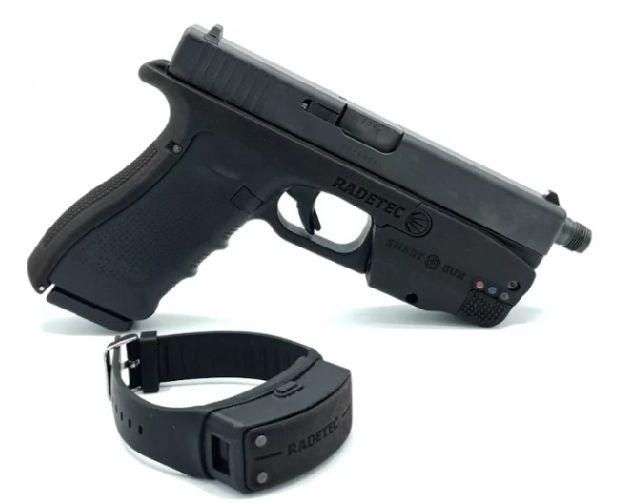 Una pistola, con la base que permite personalizarla y la pulsera que lo conecta.