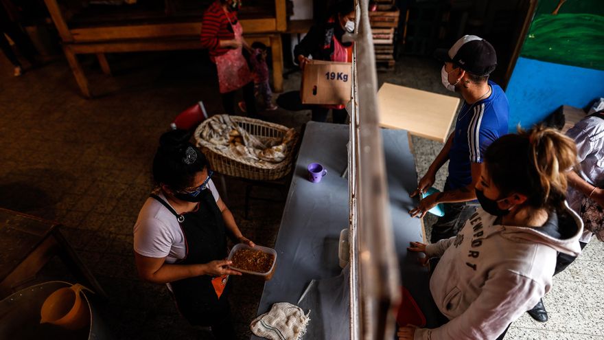 Dos argentinos recibiendo alimentos gratuitos en un comedor social de la ciudad de Buenos Aires