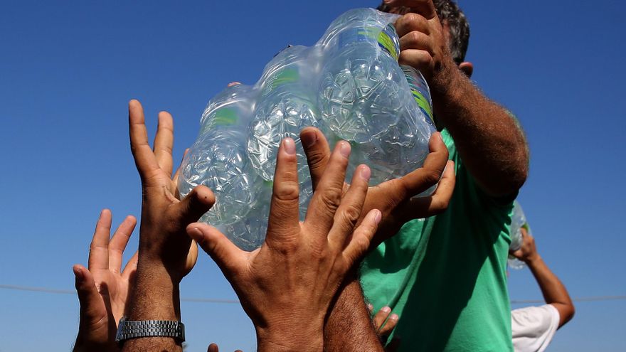 Refugiados del campo de Moria en la isla griega de Lesbos acuden a por víveres en los alrededores del campo. EFE/EPA/ORESTIS PANAGIOTOU