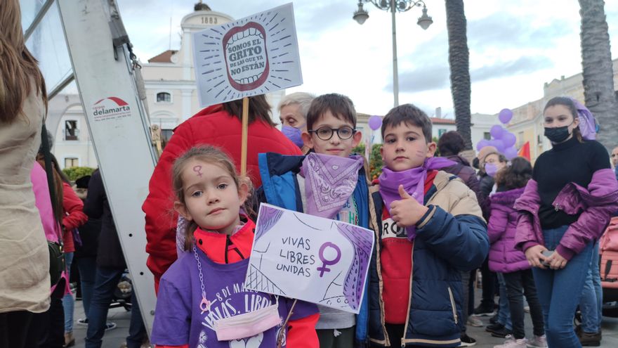 Una niña y dos niños con pancartas para reivindicar la igualdad entre hombres y mujeres en la manifestación de Mérida por el 8M