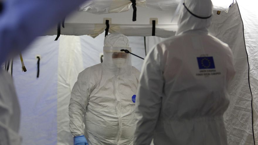 Trabajadores de proteccion civil se desinfectan contra el coronavirus en una carpa instalada en el hospital del PTS de Granada.
