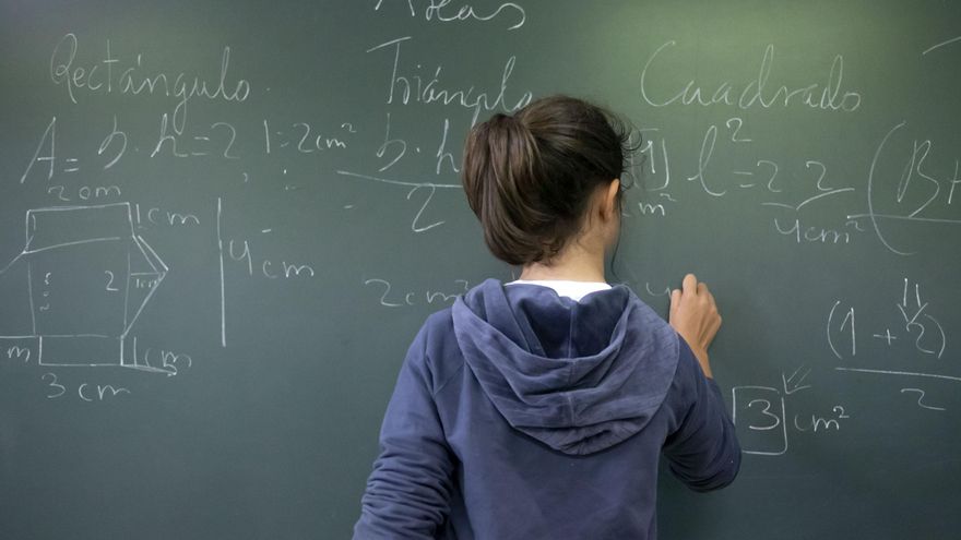 Archivo - Alumna escribe en una pizarra.-ARCHIVO