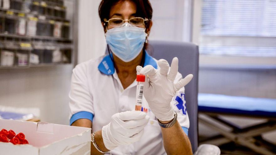 Una trabajadora sanitaria protegida sostiene una de las probetas utilizadas para la realización de PCR, en una imagen de archivo. Ricardo Rubio - Europa Press