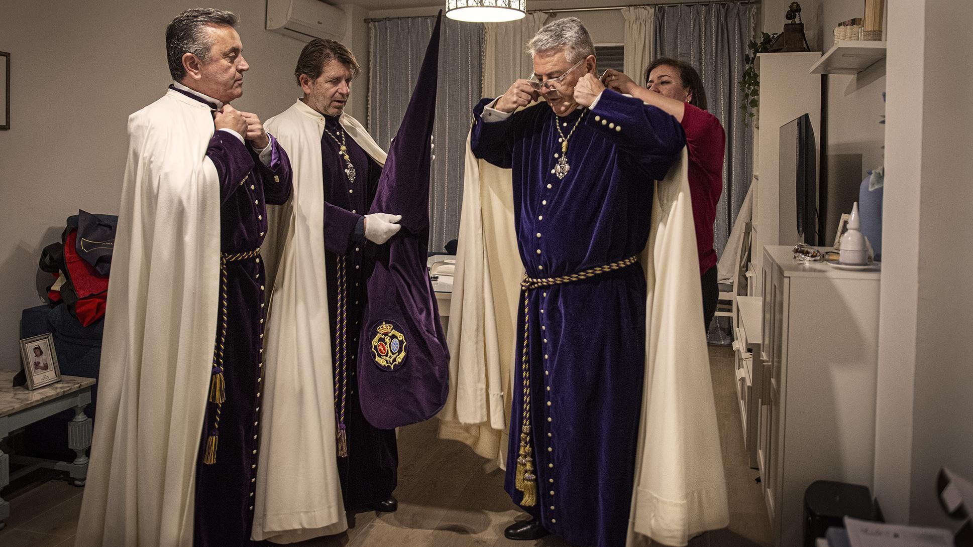 Nazarenos de la Esperanza de Triana vistiendose para su estación de Penitencia.