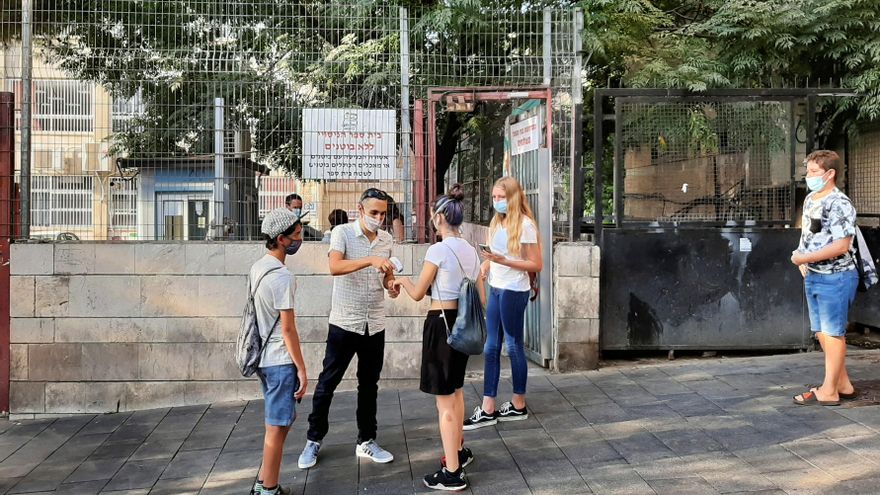 Un trabajador mide la temperatura de una alumna a las puertas de un colegio de Jerusalén, Israel 