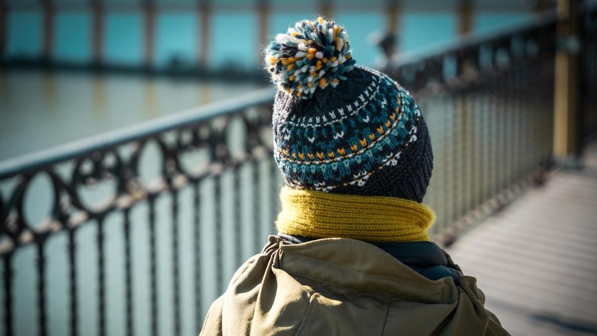 Un niño abrigado con gorro y bufanda.