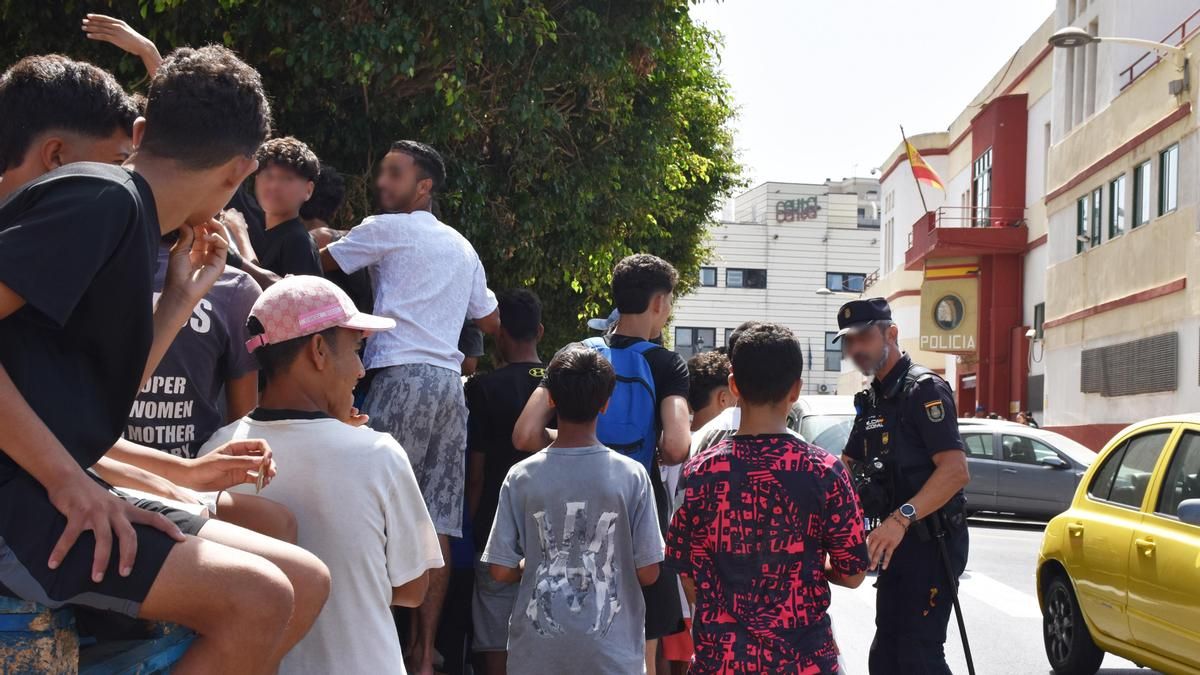 Un grupo de menores espera para ser filiado en una comisaría de la Policía Nacional, a 10 de agosto de 2026, en Ceuta (España).