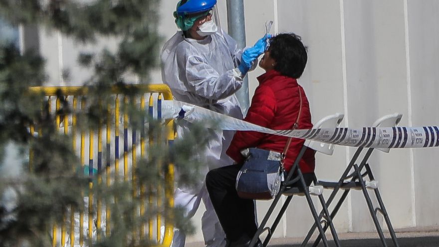 Una sanitaria realiza a una trabajadora de servicios esenciales un test rápido de coronavirus, foto de archivo