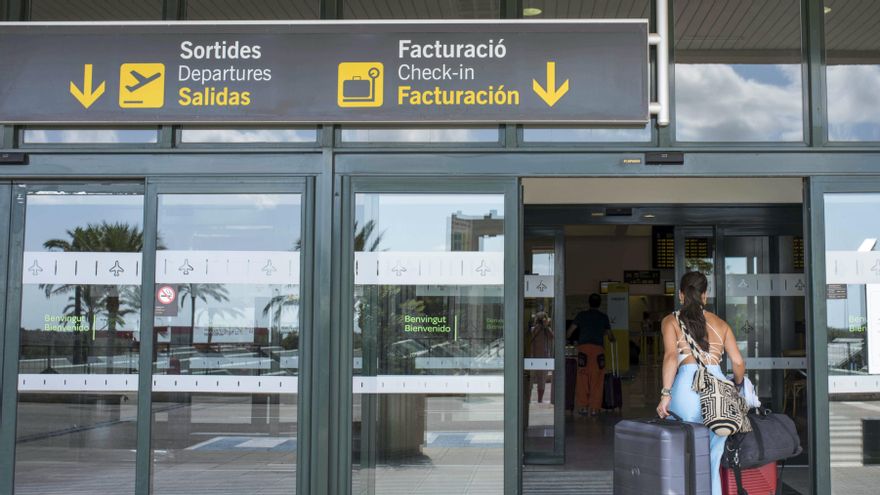 Una mujer entra al aeropuerto de Menorca.
