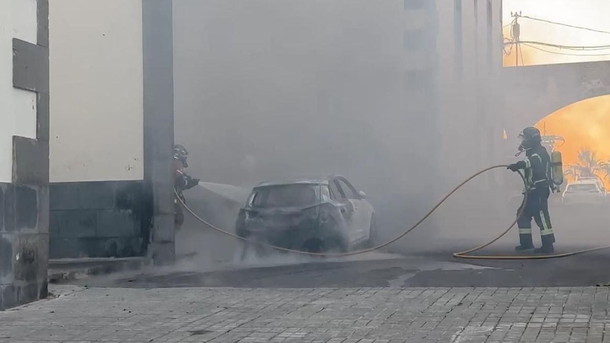 Bomberos, sofocando las llamas del coche incendiado en Tafira Alta.