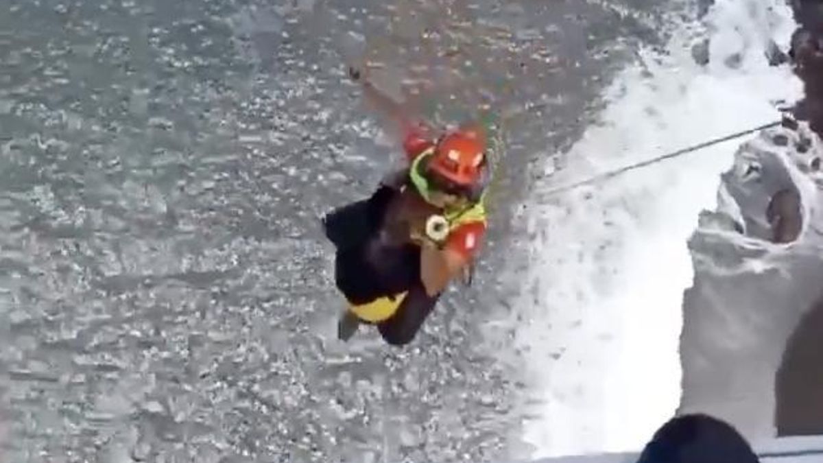 Un rescatista del GES iza a la senderista herida al helicóptero.