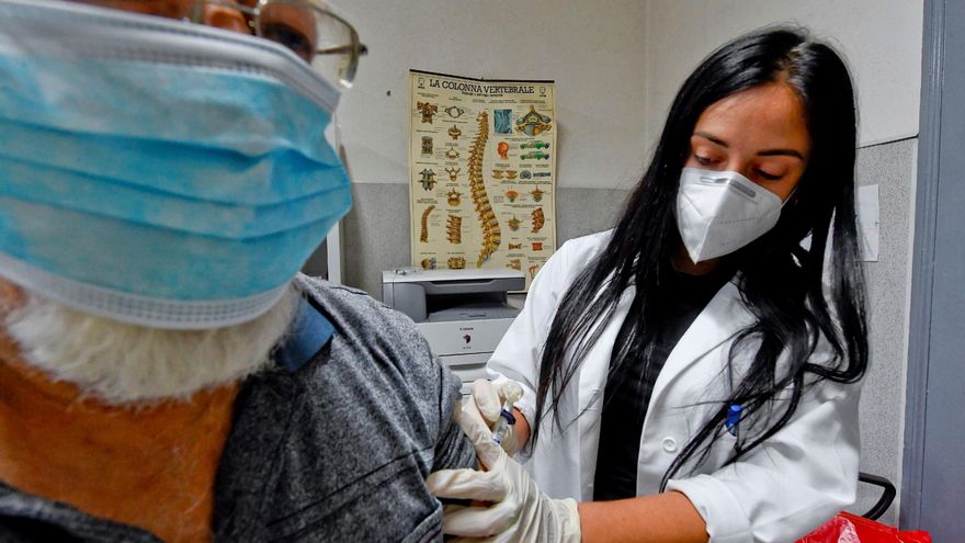 Una doctora vacuna de la gripe a un paciente, protegido con mascarilla en Napoles, Italia. EFE/EPA/CIRO FUSCO