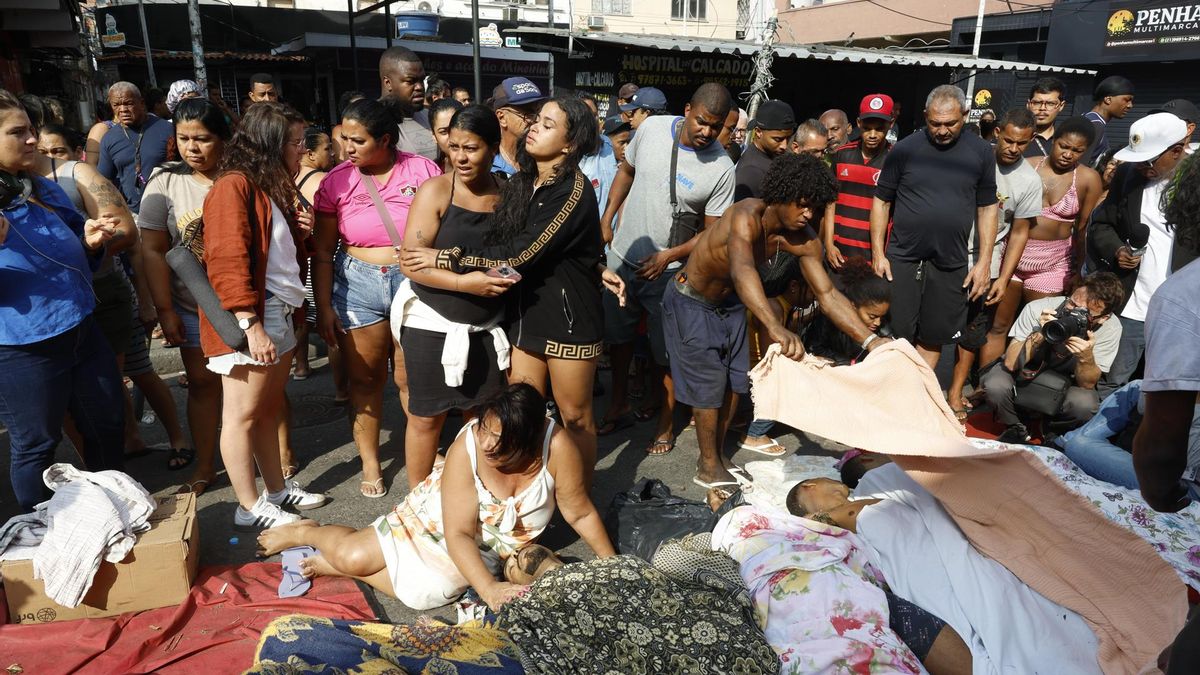 Personas observan cuerpos sin vida en una calle después de un operativo policial este miércoles, en Río de Janeiro (Brasil).