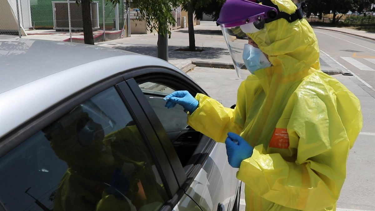 Un sanitario realiza una prueba PCR en la calle.