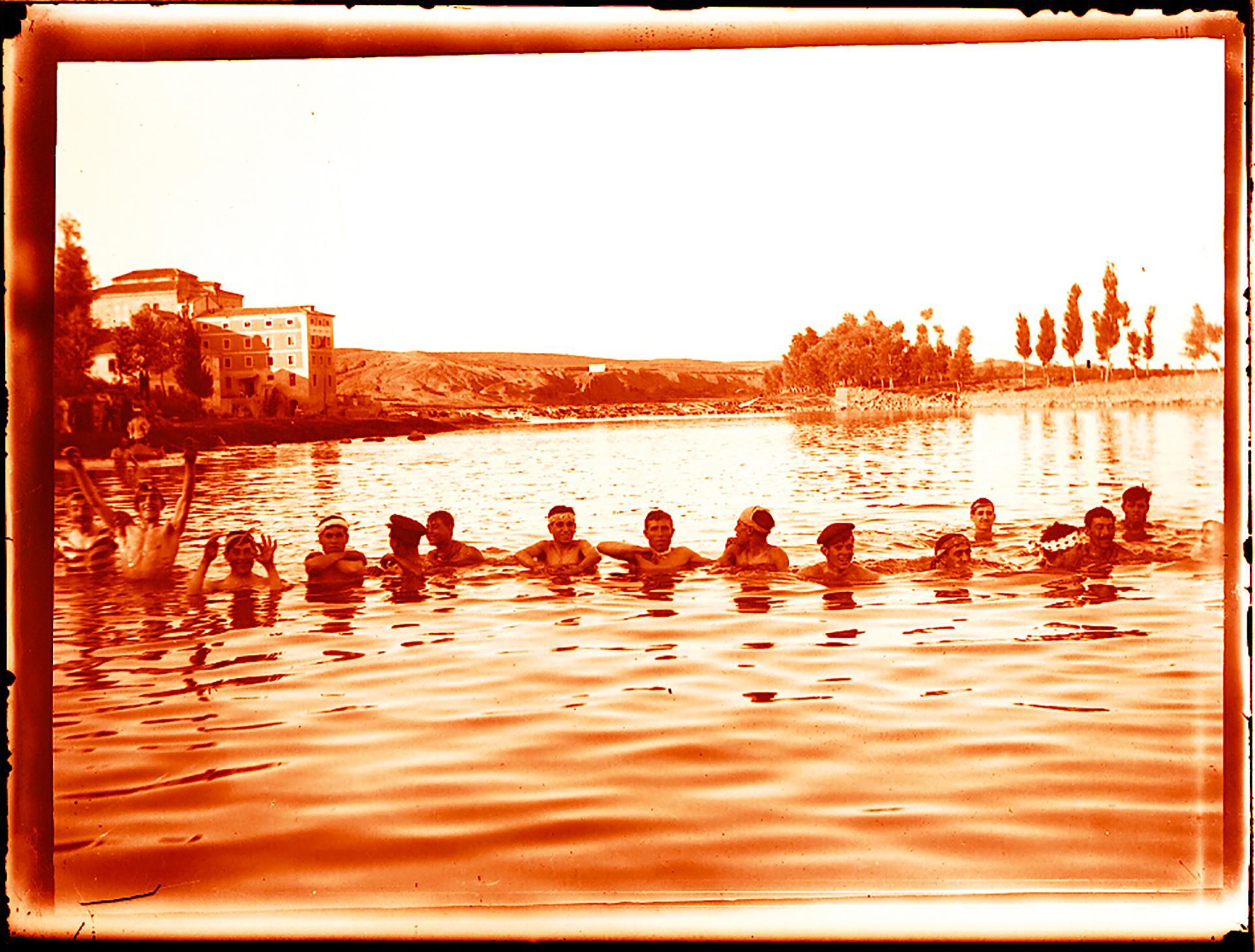 Grupo de jóvenes bañándose en el rio Tajo en el paraje de Safont, al fondo el edificio de la antigua central eléctrica. Años 30. Fotografía de Pedro Román. Fondo Rodríguez. AHP Toledo.