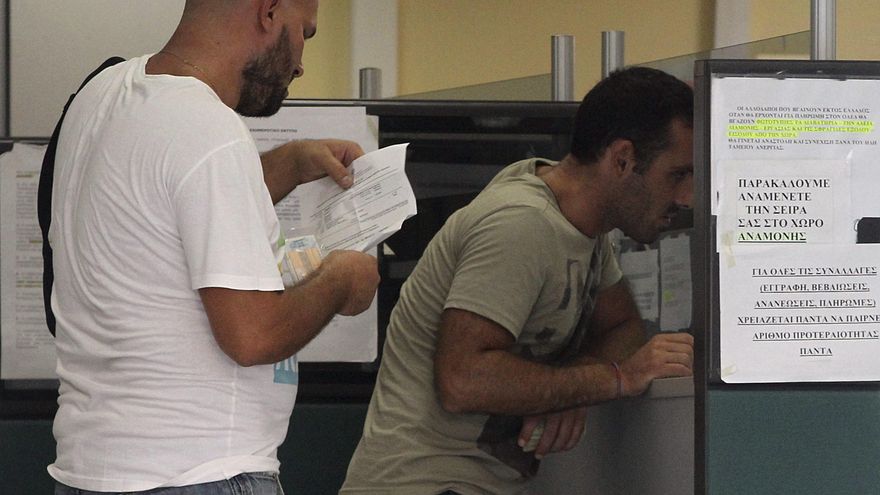 Imagen de archivo de dos hombres en una cola en un oficina de desempleo en Atenas, Grecia. EFE/Orestis Panagiotou