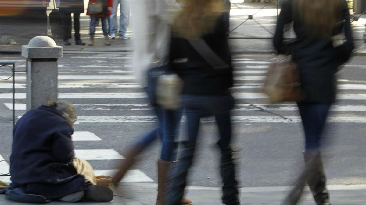 Una persona pide limosna en la Plaza de Cibeles de Madrid