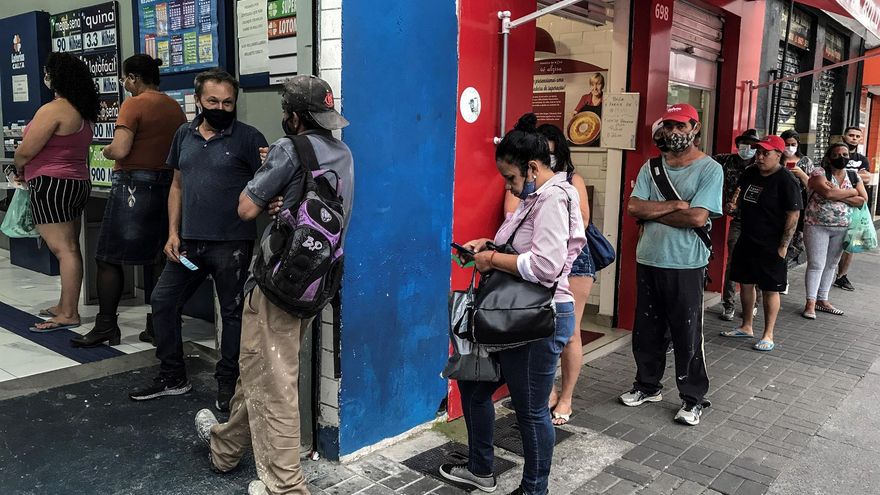 Varias personas esperan para ingresar a un establecimiento, en una ciudad en Brasil, en una fotografía de archivo.