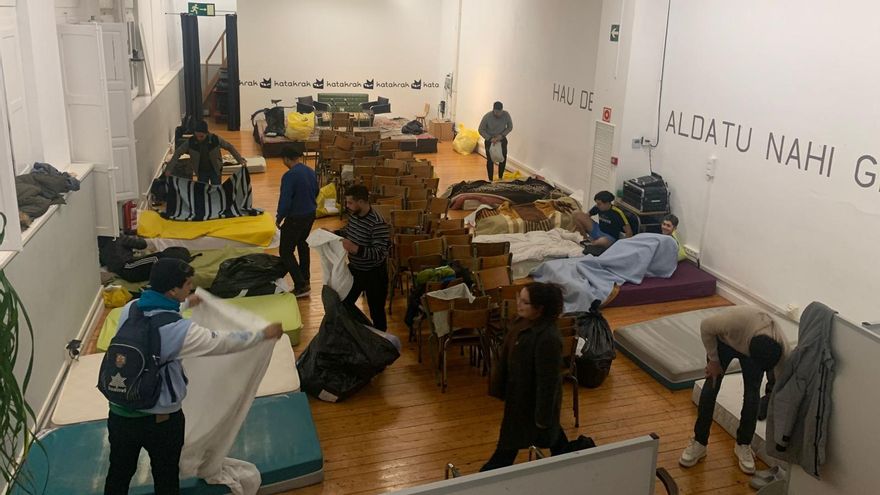 Los 16 jóvenes que pernoctan en Katakrak habilitando el salón de actos para colocar los colchones