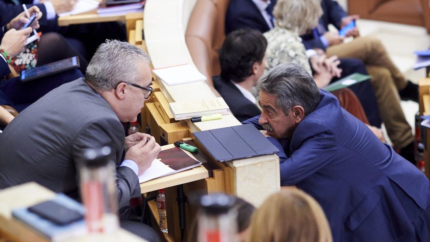 El presidente de Cantabria y secretario general del PRC, Miguel Angel Revilla (d), habla con el portavoz del PRC, Pedro José Hernando (i), durante una sesión plenaria en el Parlamento de Cantabria.