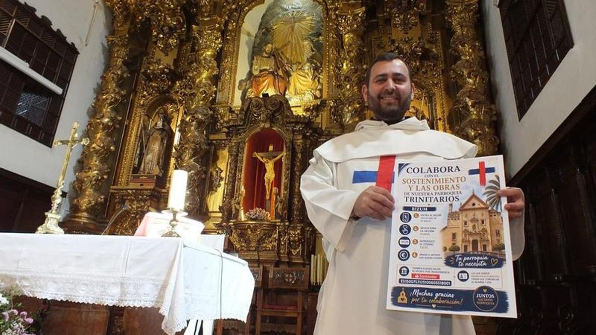 El padre Manuel García, con el cartel de la campaña en la iglesia de Los Trinitarios.