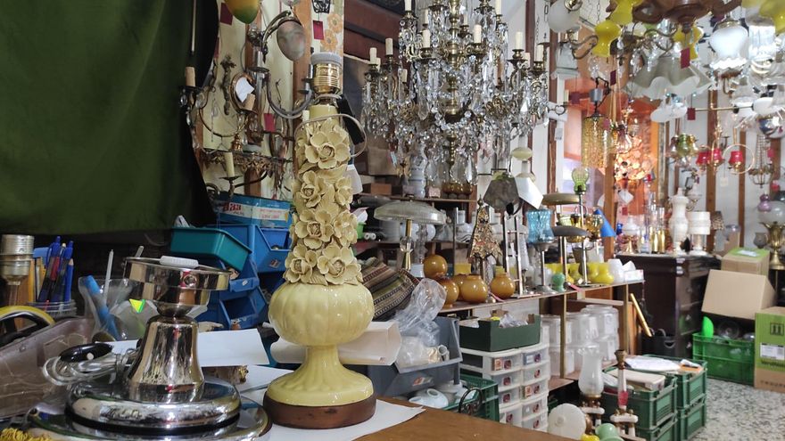 Sobre la mesa del taller, lámpara cerámica de Manises a la espera de ser reparada