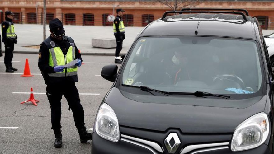 Un policía revisa la documentación aportada por los ocupantes de un vehículo en un control de seguridad montado cerca de la estación de Atocha, en Madrid, este viernes.