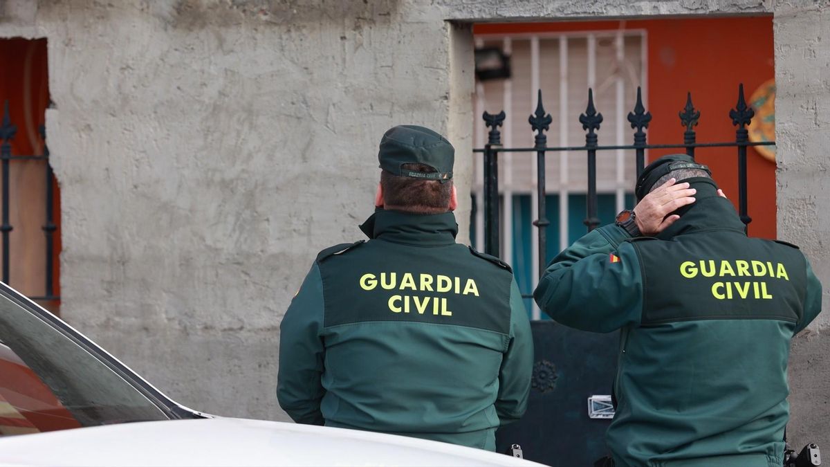 Dos agentes de la Guardia Civil, ante la casa donde apareció el cuerpo.