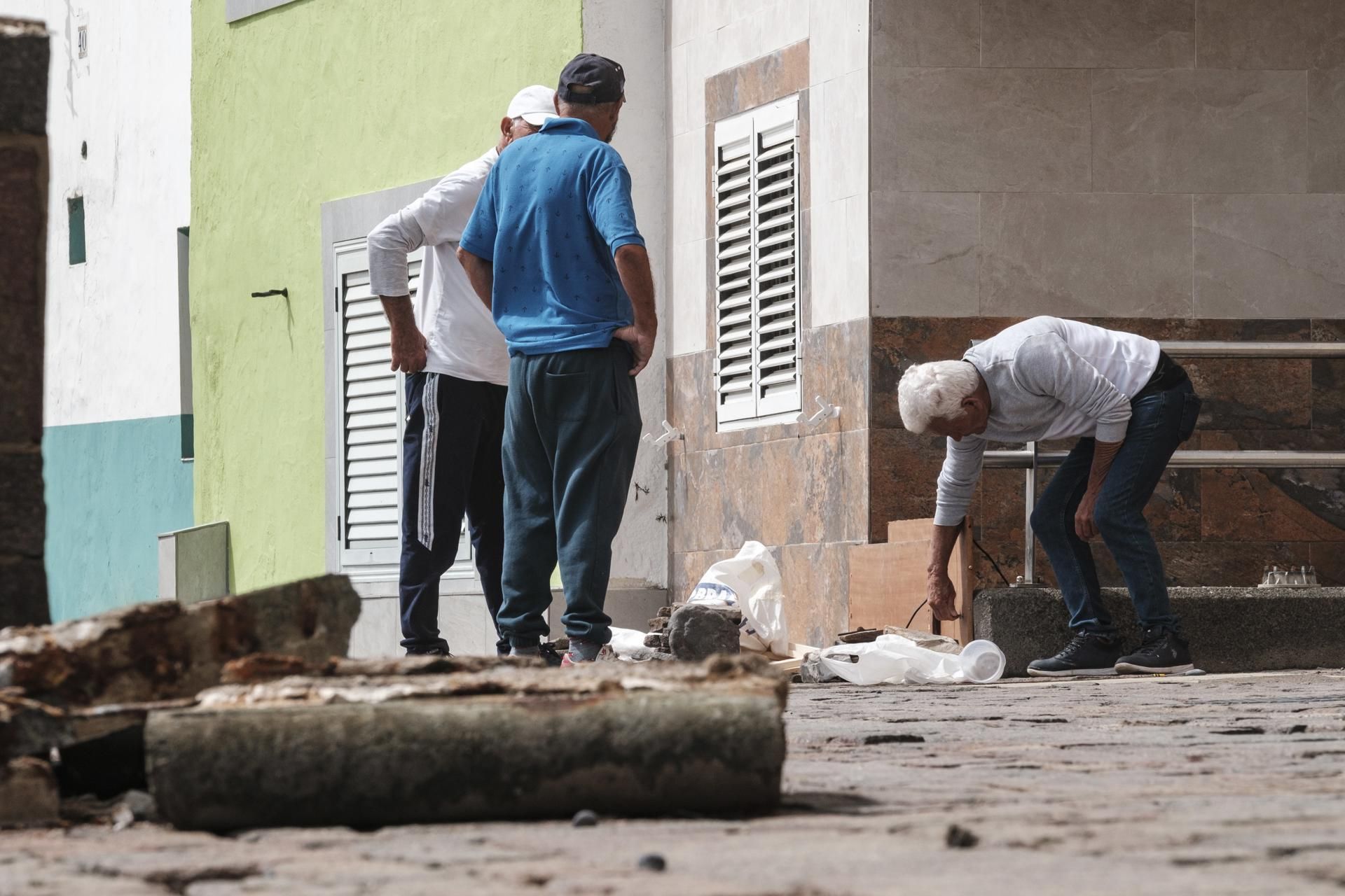 Vecinos, limpiando los desperfectos del mar en el barrio marinero de San Cristóbal.