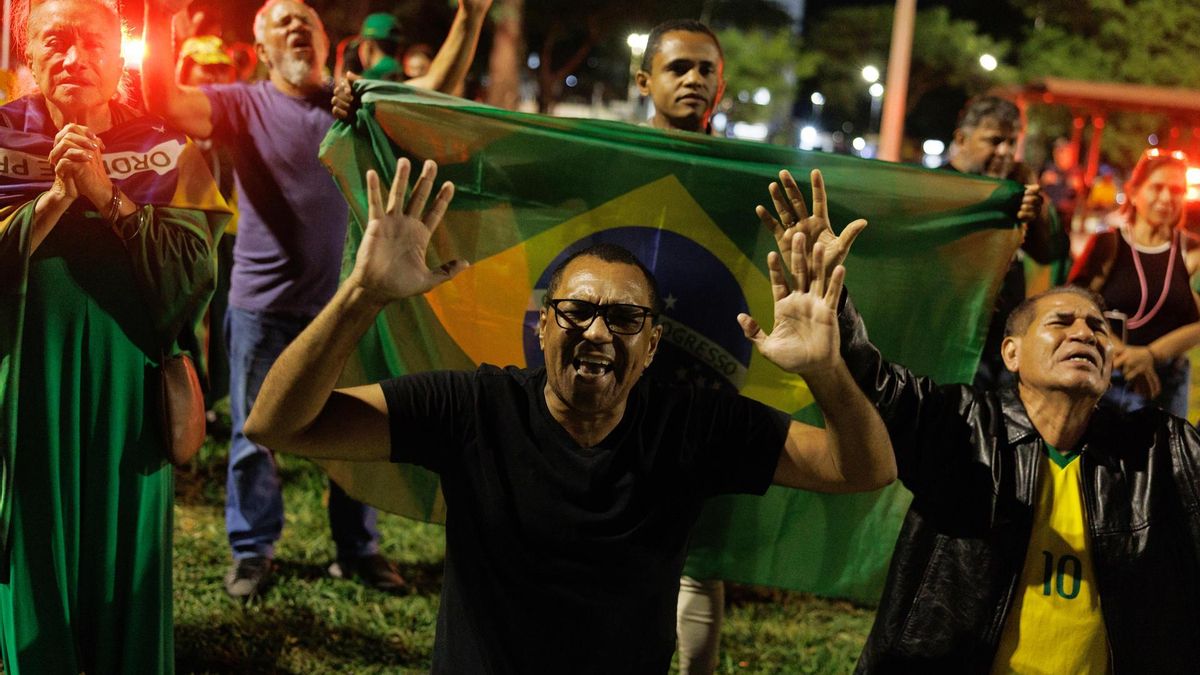 Simpatizantes del expresidente de Brasil, Jair Bolsonaro, rezan frente a la sede de la Policía Federal donde el exmandatario permanece detenido