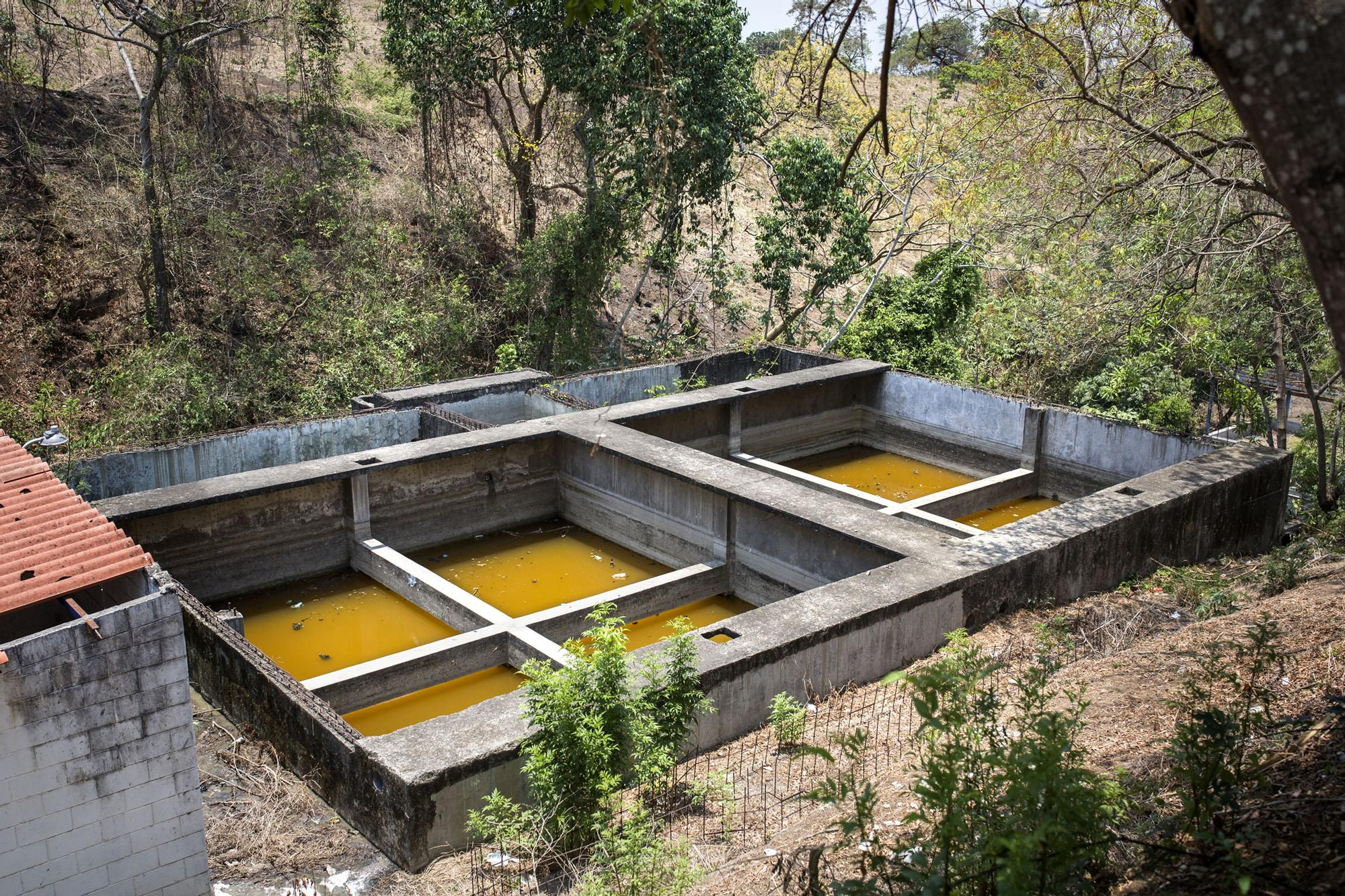 Depuradora en desuso de la comunidad Las Brisas, a las afueras de la capital, San Salvador. Las aguas negras provienen de urbanizaciones residenciales amuralladas para la clase media alta situadas en lo alto de las colinas. Estas aguas van a parar a los ríos que usan las comunidades rurales para uso doméstico a falta de agua corriente en sus casas.
