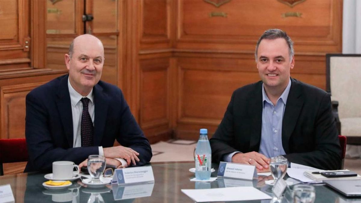 Federico Sturzenegger y Manuel Adorni.