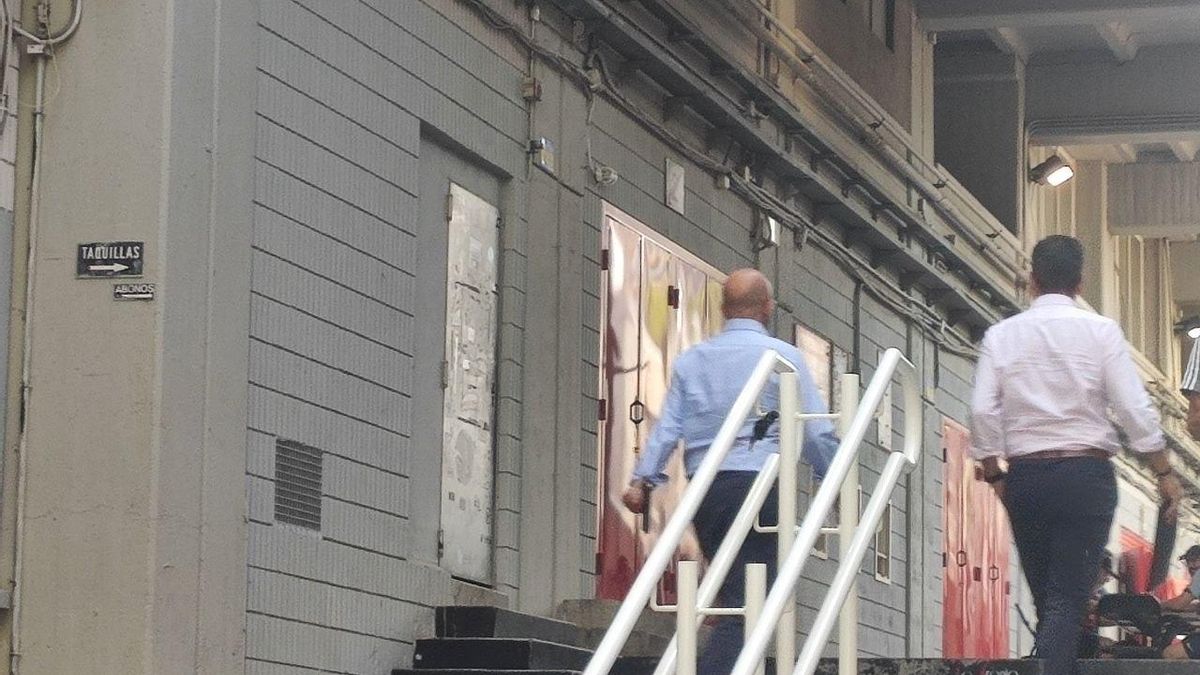 Dos profesionales acceden a las instalaciones del Estadio de Vallecas.