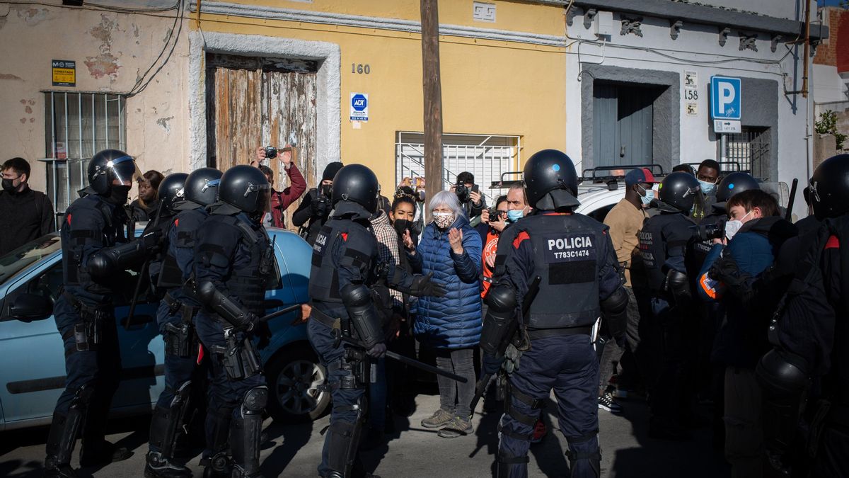 La presidenta de la CUP en el Parlament, Dolors Sabater, y la diputada 'cupaire' Basha Changue ante antidisturbios de los Mossos d'Esquadra que han desalojado una nave de Badalona (Barcelona).