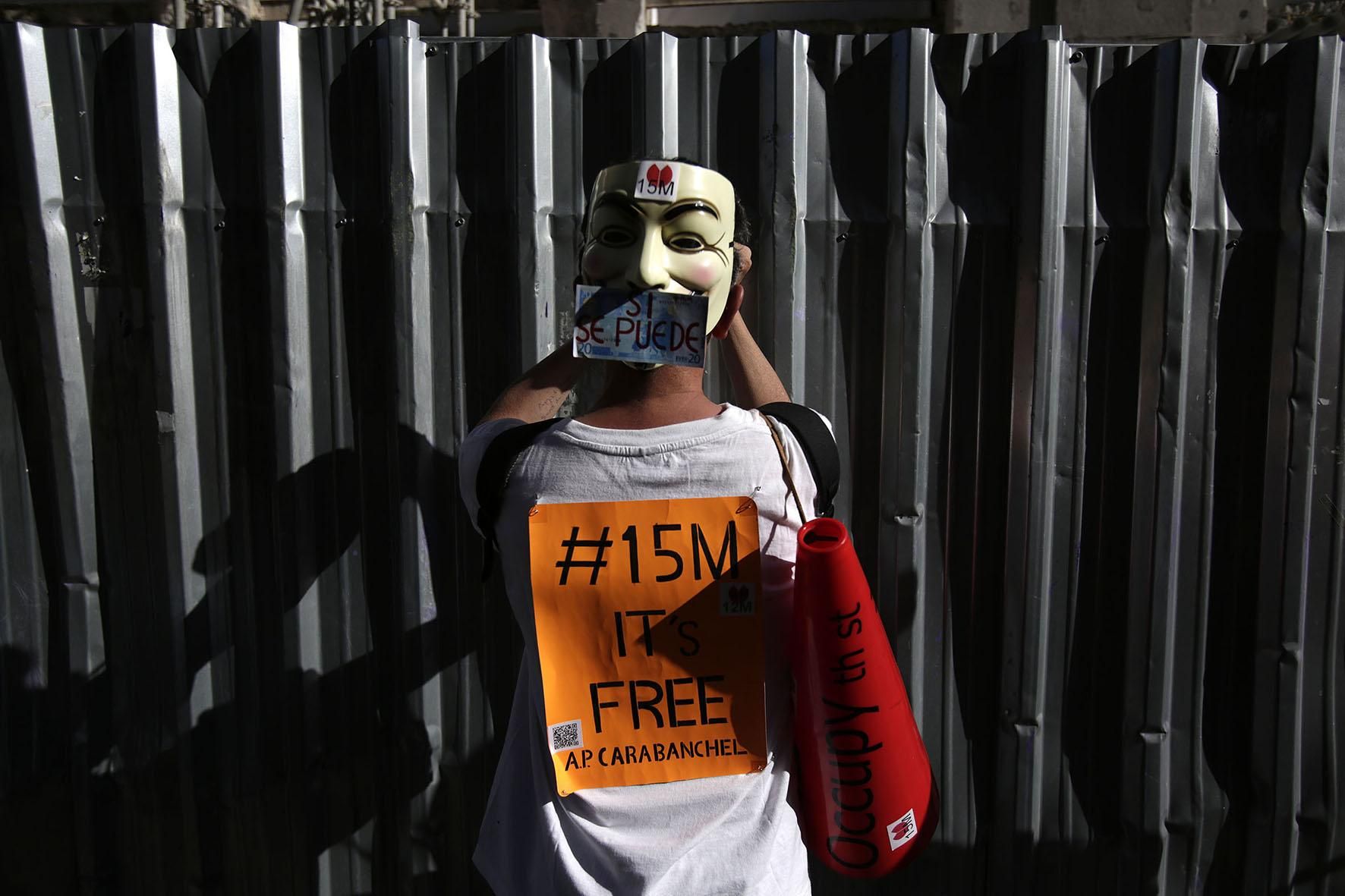 Un manifestante coloca un cartel durante la manifestación del 12M. / Fotografía: Olmo Calvo.