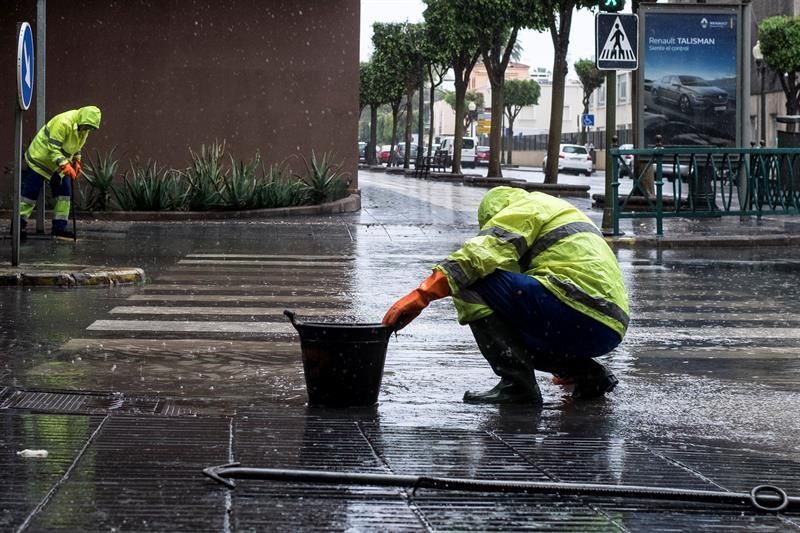 Dos operarios desatascan alcantarillas en la capital grancanaria, donde se han producido varias incidencias de este tipo