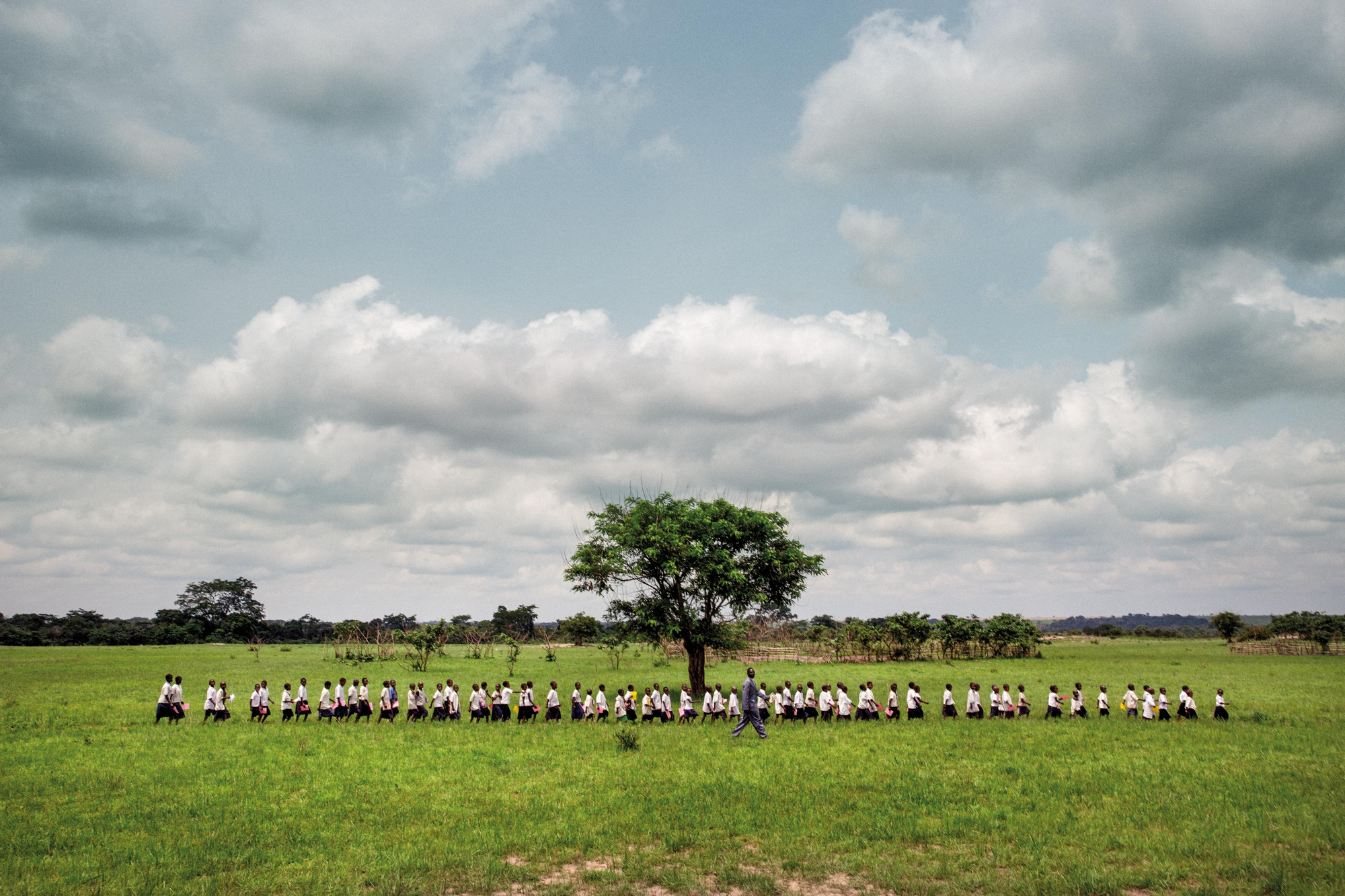 Tuve que correr, y mucho, para captar esta imagen. Estábamos vacunando en una pequeña escuela del Alto Katanga, antigua zona minera, cuando de repente se llenó la estancia. Era de aquellas veces en que cuesta tener una visión amplia de la situación. De repente, Pau Miranda, mi compañero de viaje, entró gritando y gesticulando para que saliera. Salí como pude y me fui corriendo tras él. En cuestión de segundos, me di cuenta: una fila de escolares cantando por aquellas tierras. Tenía que buscar el plano general y darme prisa, porque no se detenían. Su paso marcial casi me desfonda. Luego nos presentamos. (Dikuluy, Alto Katanga, República Democrática del Congo, 2015).