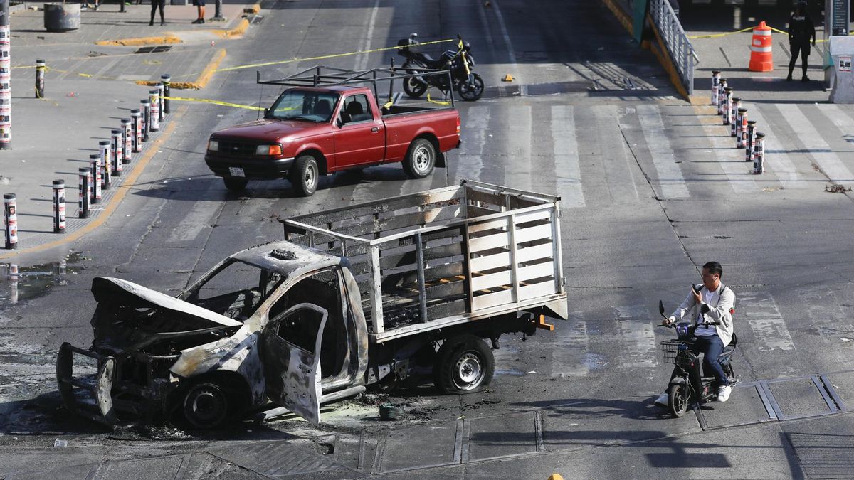 Un bloqueo con vehículos incendiados este domingo, en una vía de Guadalajara (México).