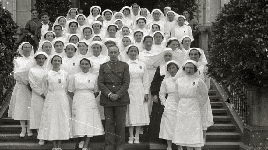 Hijas de la Caridad, con las Damas de Sanidad Militar y soldados en las escaleras del Hospital Militar General Mola, 1940