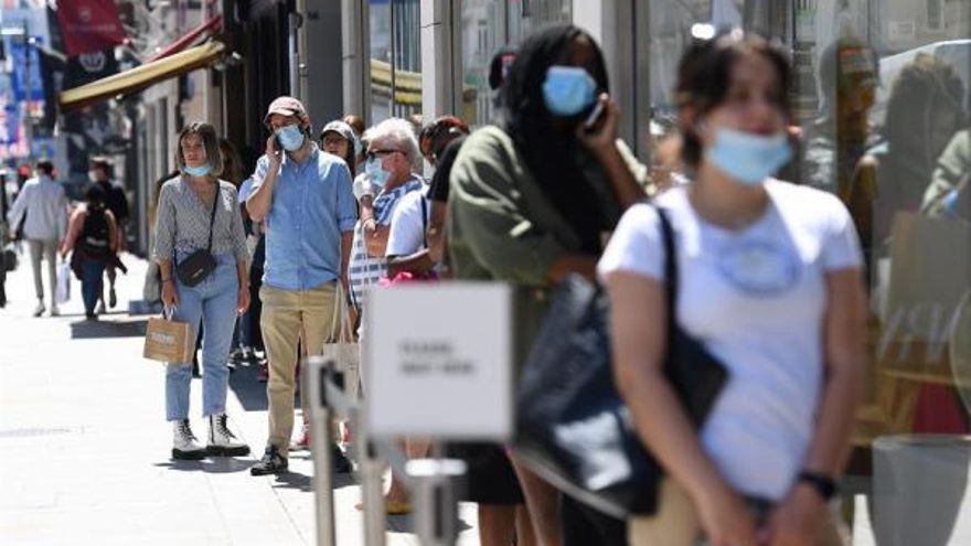 Una decena de personas con mascarilla esperan su turno en la calle para entrar en una tienda de Zara en Londres