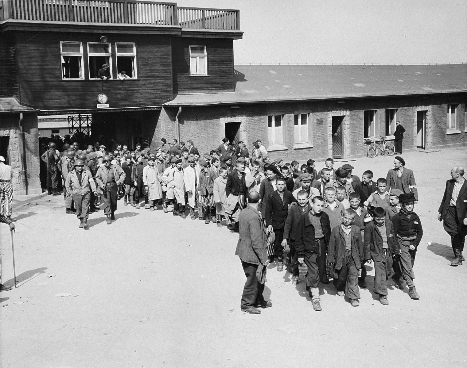 Los presos abandonan el recinto del campo de Buchenwald tras ser liberados por las tropas estadounidenses. Encabeza la formación un grupo de niños (https://nuevodiario.es/noticia/8219/internacional/se-cumple-el-75-aniversario-del-desarme-del-campo-de-concentracion-de-buchenwald.html).