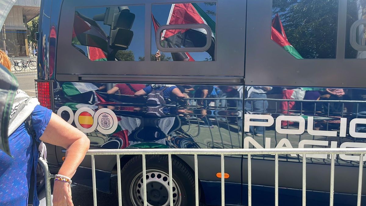 Furgón de Policía delante de manifestantes.